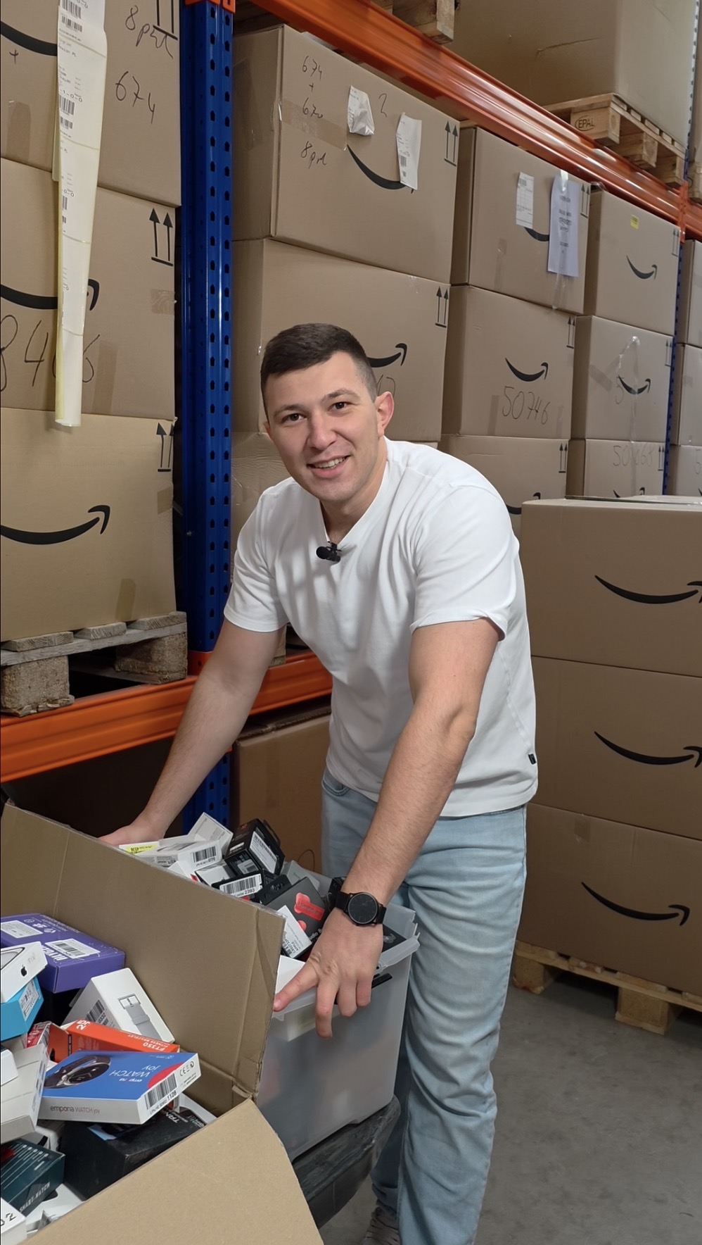 Maxim Tscherkaschin in der Lagerhalle vor Amazon-Retouren-Paletten